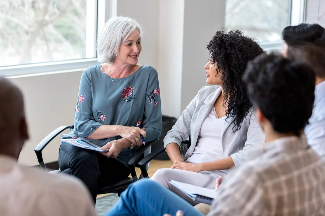 Therapist leading a supportive group therapy session at Ethos Wellness